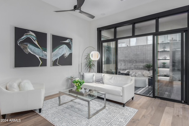 living room with light hardwood / wood-style flooring and ceiling fan