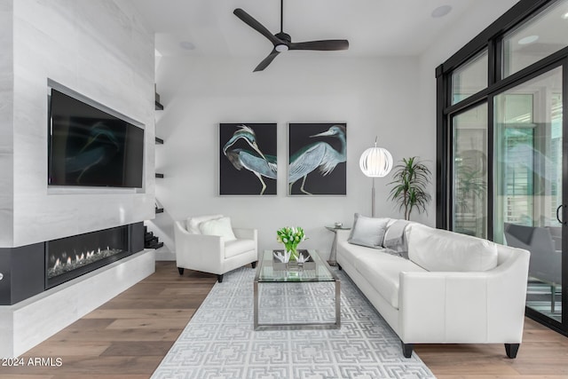 living room featuring a fireplace, hardwood / wood-style flooring, and ceiling fan