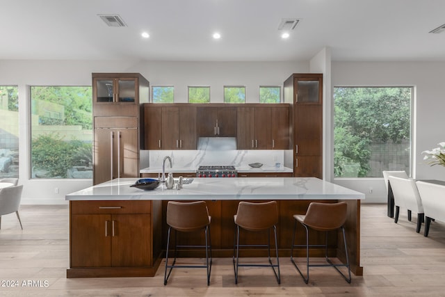 kitchen featuring a large island, paneled built in refrigerator, and light hardwood / wood-style floors