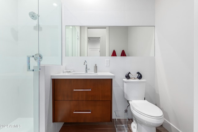 bathroom featuring vanity, toilet, tile walls, and an enclosed shower