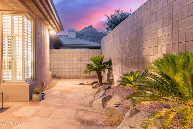 patio terrace at dusk featuring a mountain view