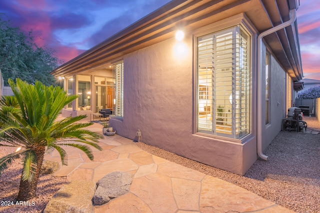 property exterior at dusk with a patio area