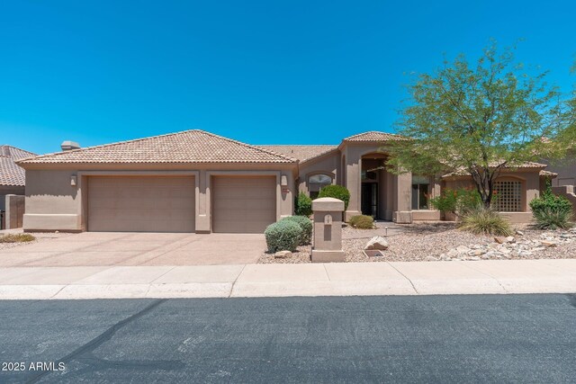 12120 E Cortez Dr, Scottsdale, AZ 85259 - mediterranean / spanish-style home with stucco siding, a garage, a tile roof, and concrete driveway