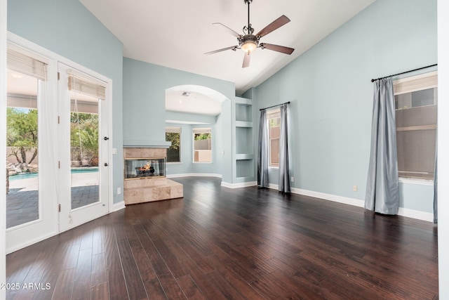 12120 E Cortez Dr, Scottsdale, AZ 85259 - unfurnished living room featuring arched walkways, ceiling fan, vaulted ceiling, a multi sided fireplace, and wood finished floors