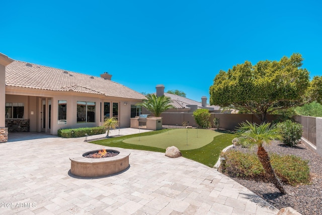 12120 E Cortez Dr, Scottsdale, AZ 85259 - fenced backyard featuring an area to practice putting, a patio, and a fire pit