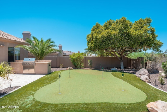 12120 E Cortez Dr, Scottsdale, AZ 85259 - fenced backyard featuring area for grilling, a putting area, and a patio area