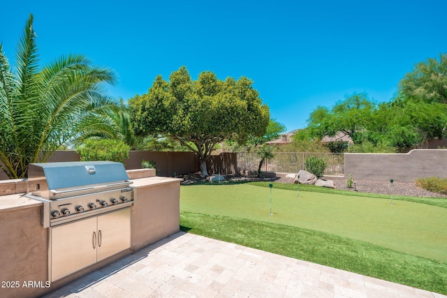 12120 E Cortez Dr, Scottsdale, AZ 85259 - fenced backyard featuring a putting green, an outdoor kitchen, and a patio