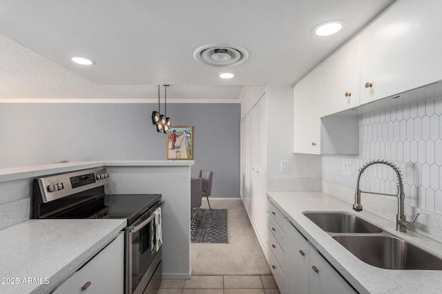 kitchen featuring sink, stainless steel electric range oven, hanging light fixtures, white cabinets, and light tile patterned flooring