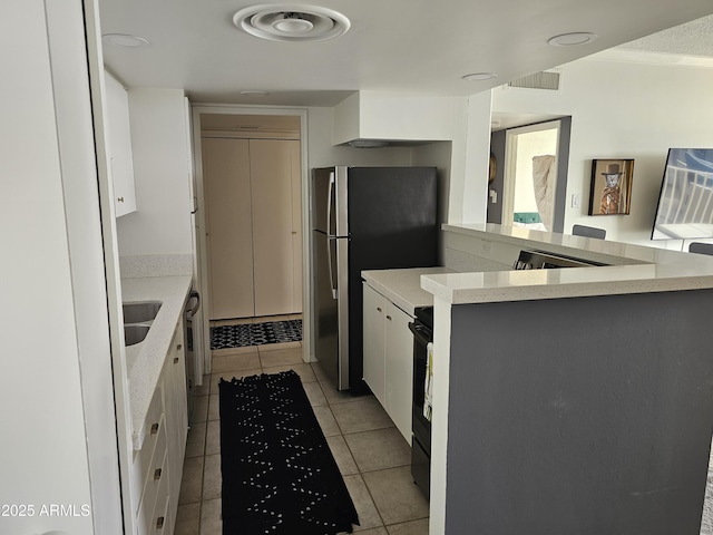 kitchen featuring sink, white cabinetry, light tile patterned flooring, black / electric stove, and kitchen peninsula