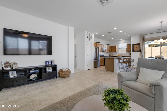 living area with a chandelier, light tile patterned flooring, visible vents, and recessed lighting