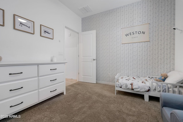 bedroom featuring an accent wall, carpet, visible vents, and wallpapered walls