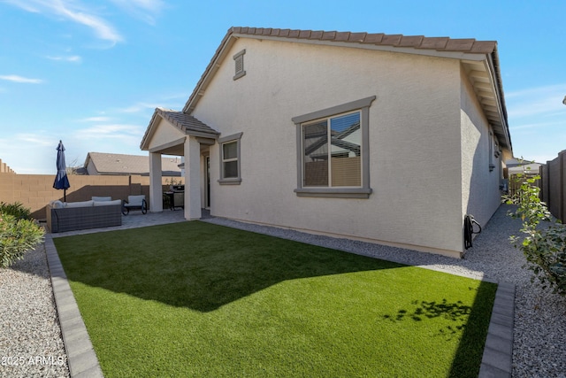 rear view of property with outdoor lounge area, a fenced backyard, and stucco siding