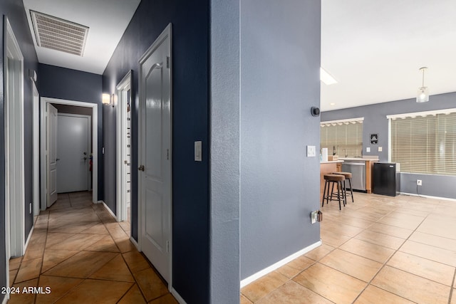 hall featuring light tile patterned floors