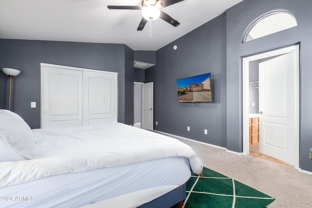 bedroom featuring ceiling fan, a closet, carpet floors, and lofted ceiling