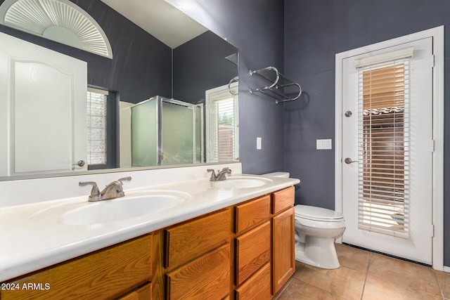 bathroom with tile patterned floors, vanity, a shower with shower door, and toilet