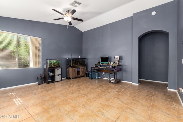 interior space featuring ceiling fan, light tile patterned floors, and lofted ceiling