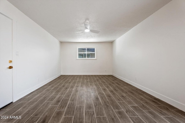 spare room featuring ceiling fan, dark hardwood / wood-style flooring, and a textured ceiling