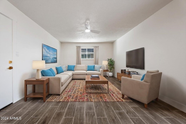 living room with ceiling fan, dark wood-type flooring, and a textured ceiling