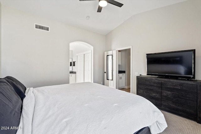 carpeted bedroom featuring ensuite bath, lofted ceiling, and ceiling fan