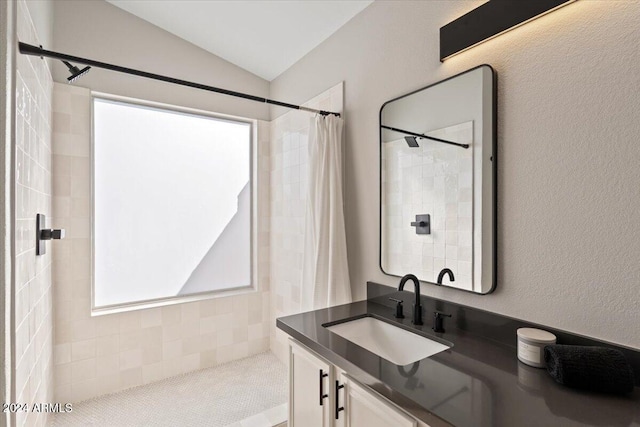 bathroom featuring curtained shower, vanity, and vaulted ceiling