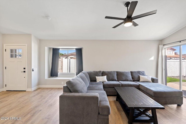 living room with plenty of natural light, ceiling fan, vaulted ceiling, and light hardwood / wood-style flooring