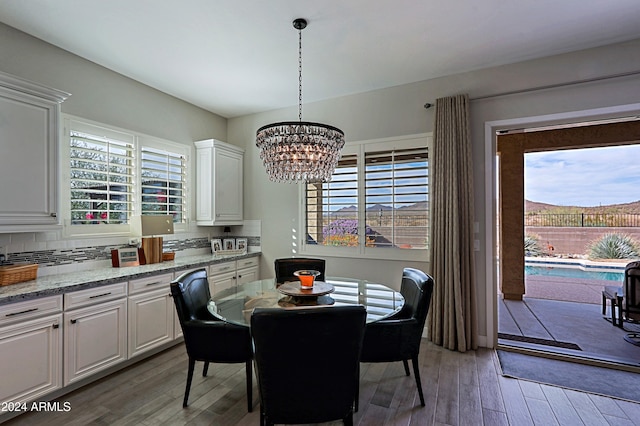 dining area with wood-type flooring and an inviting chandelier