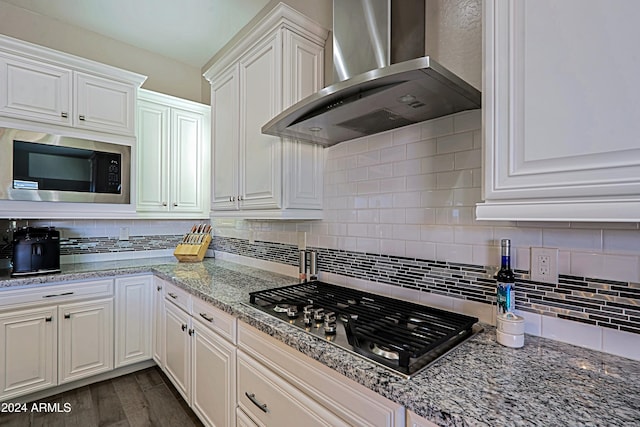 kitchen with white cabinets, stainless steel appliances, dark hardwood / wood-style floors, and wall chimney range hood