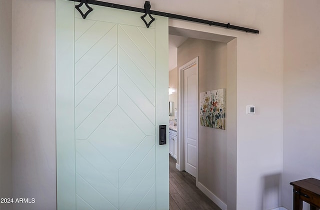 hallway with dark hardwood / wood-style floors and a barn door