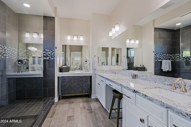 bathroom with vanity, wood-type flooring, and tiled shower