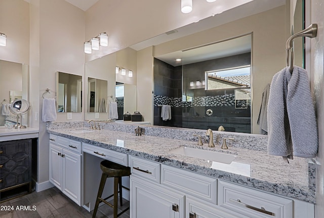 bathroom with a tile shower, vanity, and hardwood / wood-style floors