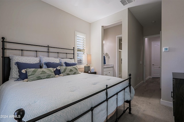 carpeted bedroom featuring ensuite bath