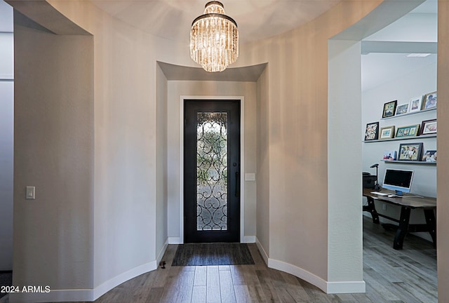 foyer featuring wood-type flooring and a notable chandelier