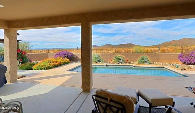 view of swimming pool featuring a mountain view and a patio