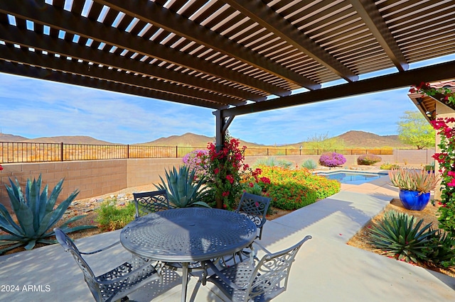 view of patio / terrace featuring a mountain view, a pergola, and a fenced in pool