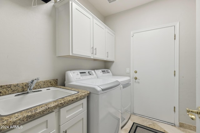 laundry room featuring light tile patterned flooring, cabinets, sink, and washing machine and clothes dryer