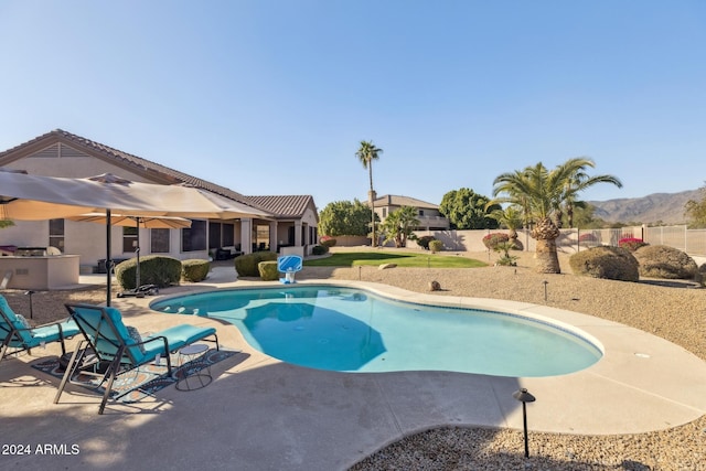 view of swimming pool featuring a mountain view and a patio