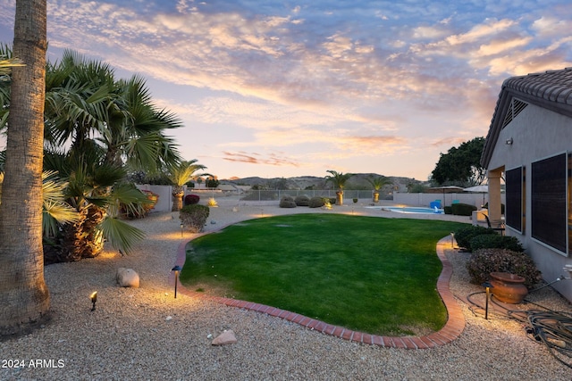 yard at dusk with a fenced in pool