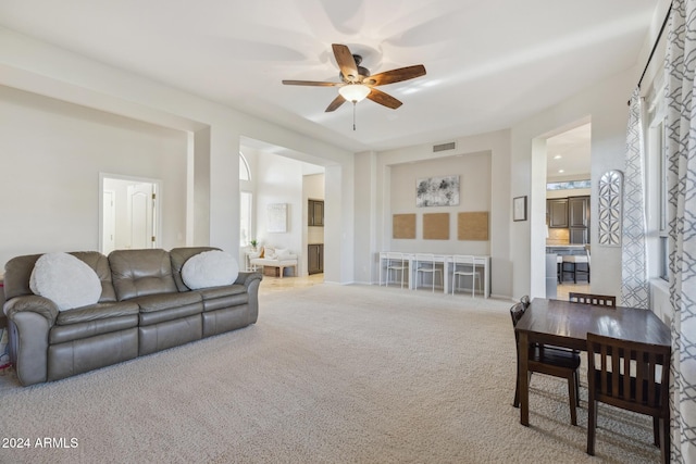 carpeted living room with ceiling fan