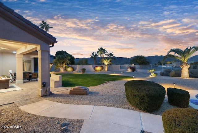 yard at dusk with a mountain view and a patio area