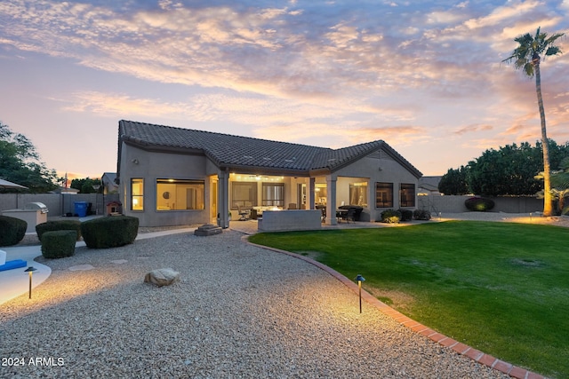 view of front of home featuring a lawn, outdoor lounge area, and a patio