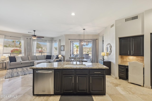 kitchen with decorative backsplash, pendant lighting, light stone counters, and sink