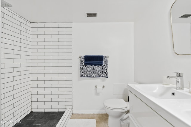 full bath featuring vanity, toilet, visible vents, and a tile shower