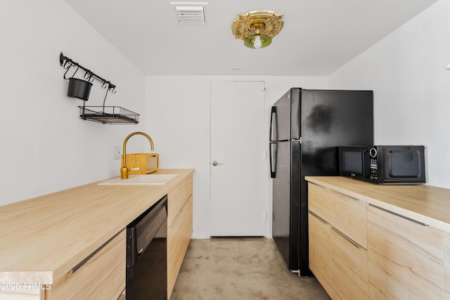 kitchen featuring light brown cabinets, visible vents, a sink, black appliances, and modern cabinets