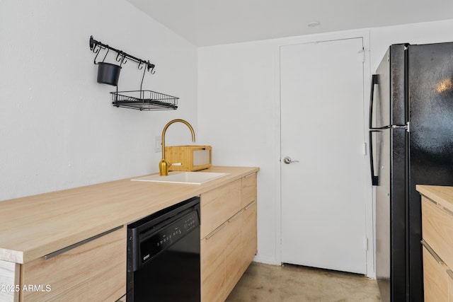 kitchen with light brown cabinets, a sink, black appliances, light countertops, and concrete flooring