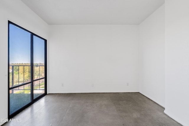 empty room featuring baseboards and concrete floors