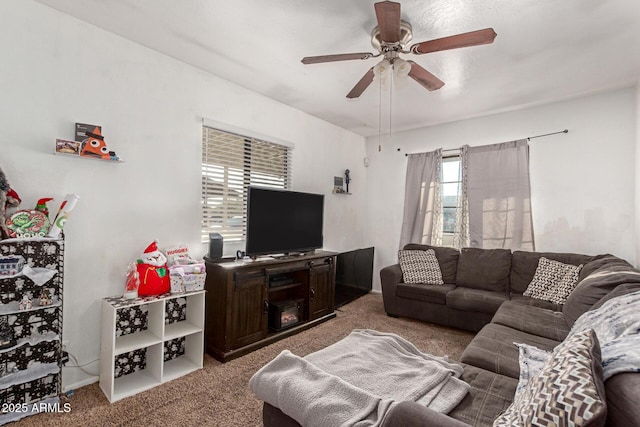 carpeted living area with ceiling fan