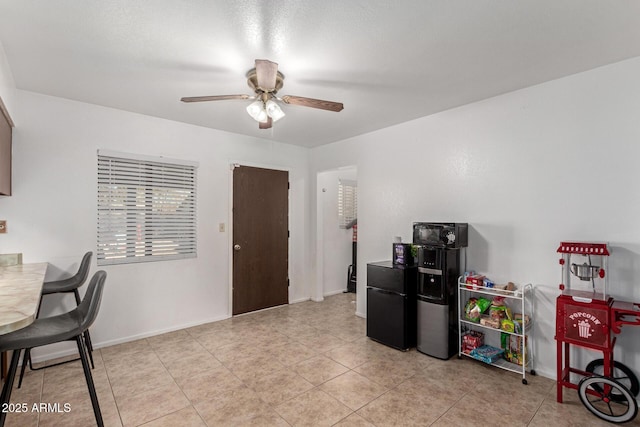 office space featuring ceiling fan, light tile patterned floors, and baseboards