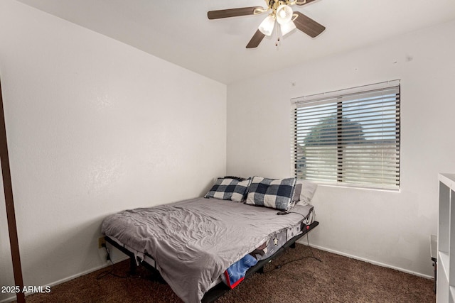 carpeted bedroom with ceiling fan and baseboards