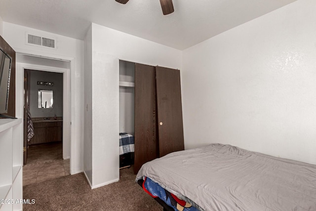 carpeted bedroom with ceiling fan, a closet, and visible vents