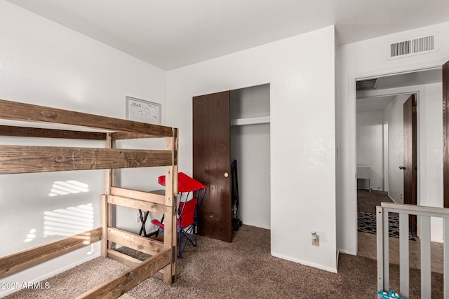 carpeted bedroom featuring visible vents and a closet